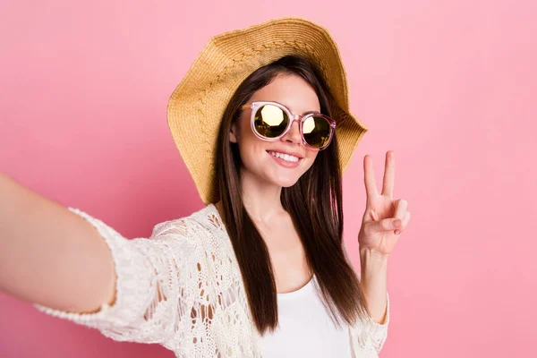 Porträtt av charmiga glada flicka ta selfie toothy leende fingrar visar v-tecken isolerad på rosa färg bakgrund — Stockfoto