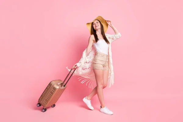 Foto de brilhante bonito jovem senhora desgaste renda cardigan cap sorrindo segurando saco olhando para cima espaço vazio isolado cor rosa fundo — Fotografia de Stock