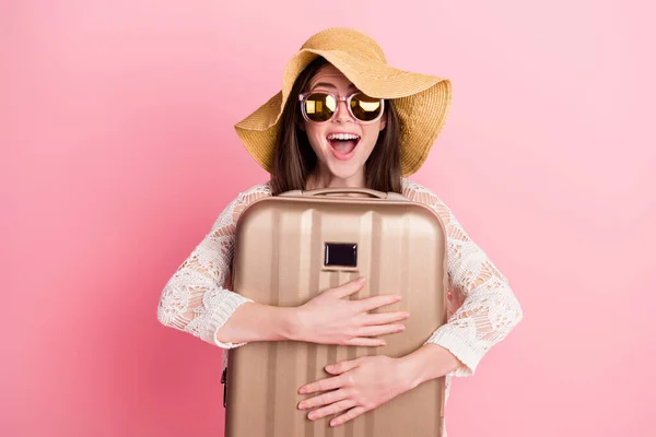 照片上可爱的、印象深刻的年轻女士头戴花边羊毛衫，笑着抱着手提箱，孤立的粉色背景 — 图库照片