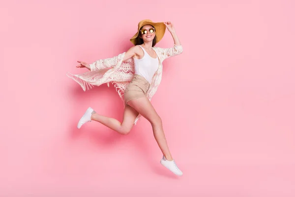 Фото красивої молодої жінки, одягненої в білий кардиган головний убір, стрибає з високим бігом швидко ізольований рожевий кольоровий фон — стокове фото