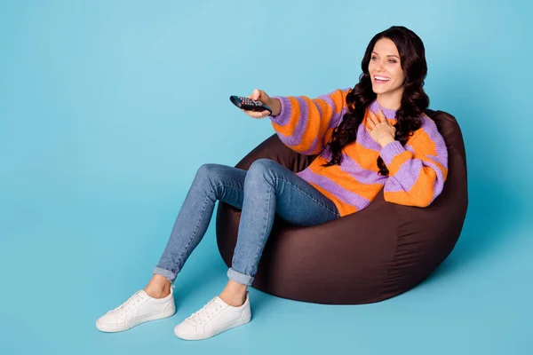 Retrato de menina alegre atraente sentado na cadeira saco assistindo engraçado comediante show isolado sobre fundo de cor azul brilhante — Fotografia de Stock
