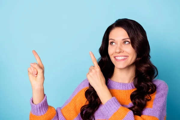 Fénykép a fiatal vidám lány boldog mosoly jelzi ujjak üres tér hirdetés promo választás elszigetelt helyett kék színű háttér — Stock Fotó