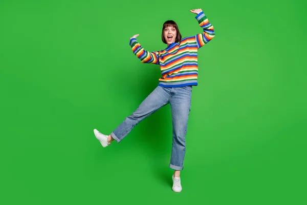 Pleine longueur photo de drôle brillant jeune femme porter pull rayé souriant dansant isolé fond de couleur verte — Photo