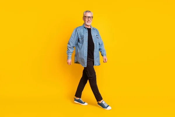 Teljes test profil fotó vicces nagyapa megy viselni szemüveg kabát nadrág elszigetelt sárga háttér — Stock Fotó