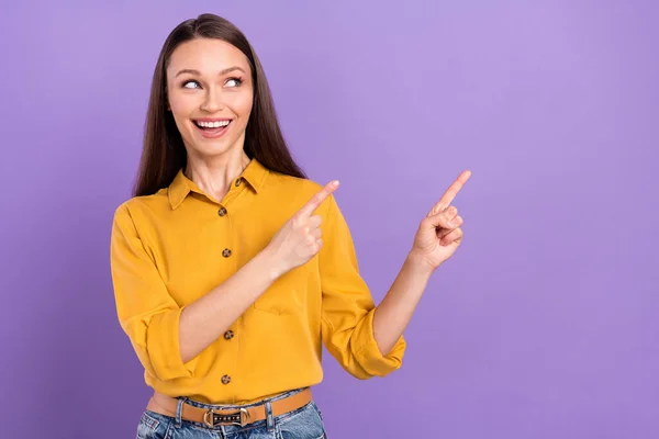 Photo of impressed millennial lady point empty space wear yellow shirt isolated on vivid violet color background — Stockfoto