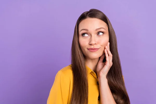 Photo of flirty young lady touch face look empty space wear yellow shirt isolated on vivid violet color background — Stockfoto