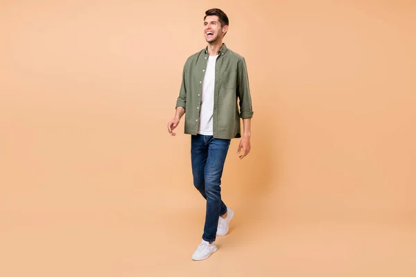 Photo of funny handsome young gentleman wear khaki shirt walking laughing smiling isolated beige color background — Stock Photo, Image
