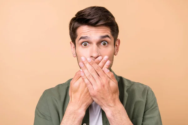 Photo of afraid scared young man hold hands cover mouth face tell secret isolated on pastel beige color background — Stok fotoğraf