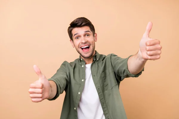 Photo of attractive happy young cheerful man make thumbs up recommend isolated on beige color background — 图库照片