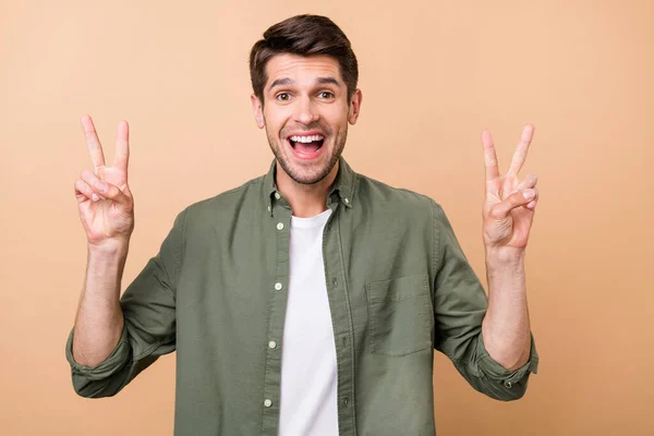 Foto van charmante vrolijke man maken v-tekens hallo goed humeur geïsoleerd op beige kleur achtergrond — Stockfoto