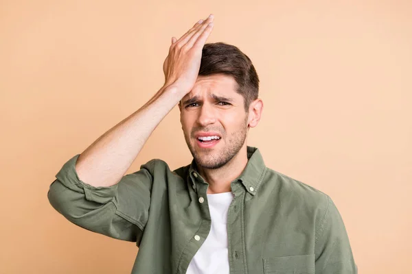 Foto van ongelukkige overstuur jonge man houden hand hoofdpijn lijden geïsoleerd op pastel beige kleur achtergrond — Stockfoto
