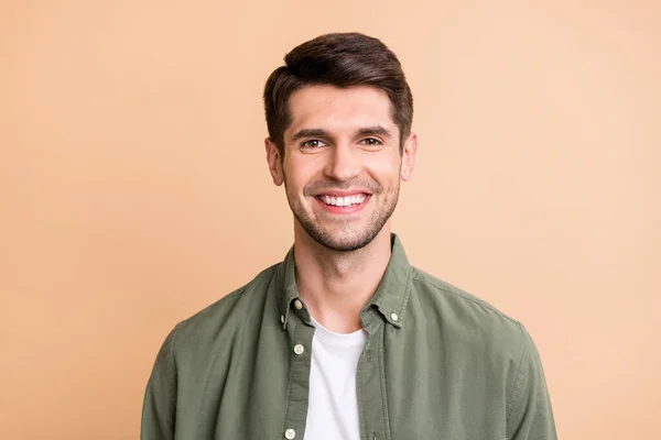 Photo of sweet adorable young guy dressed green shirt smiling isolated beige color background — Stok fotoğraf