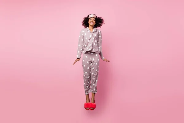 Photo of pretty sweet wavy dark skin lady dotted sleepwear jumping high isolated pink color background — ストック写真