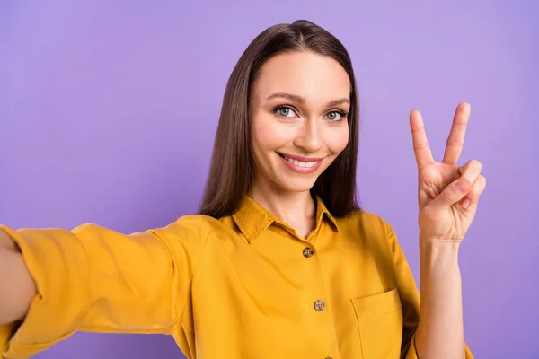 Foto retrato de mulher sorridente mostrando gesto v-sinal sorrindo tirando selfie isolado no fundo cor violeta pastel — Fotografia de Stock