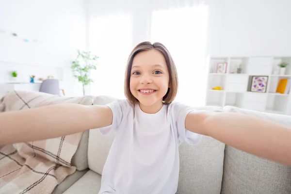 Foto de joven atractiva alegre niña feliz sonrisa positiva disparar video blogger hacer selfie casa —  Fotos de Stock