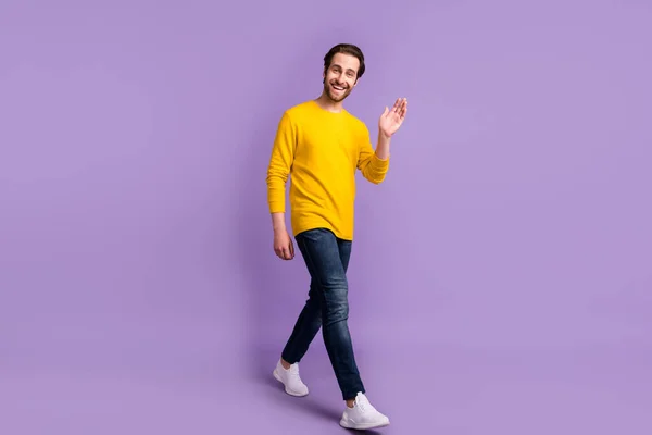 Volledige lichaamsomvang uitzicht van aantrekkelijke vrolijke man gaan zwaaien je hi geïsoleerd over pastel violet paarse kleur achtergrond — Stockfoto