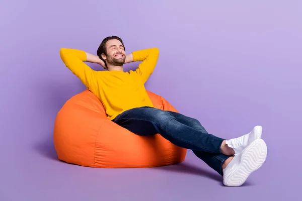 Pleine longueur taille du corps photo homme souriant posé dans un sac de haricot relaxant isolé fond de couleur pourpre pastel — Photo