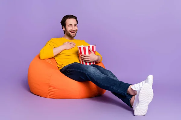 Longitud completa cuerpo tamaño foto chico sentado en beanbag riendo viendo película comedia aislado pastel púrpura color fondo —  Fotos de Stock
