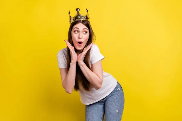 Foto de menina animada feliz sorriso positivo olhar espaço vazio desgaste coroa dourada isolado sobre fundo de cor amarela — Fotografia de Stock