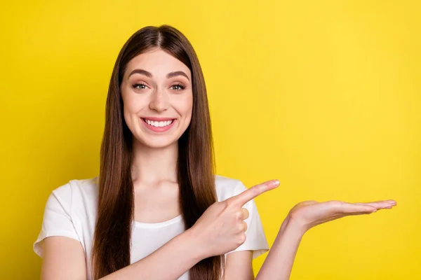 Foto retrato de mujer señalando el espacio en blanco del dedo sonriendo aislado color amarillo brillante fondo — Foto de Stock