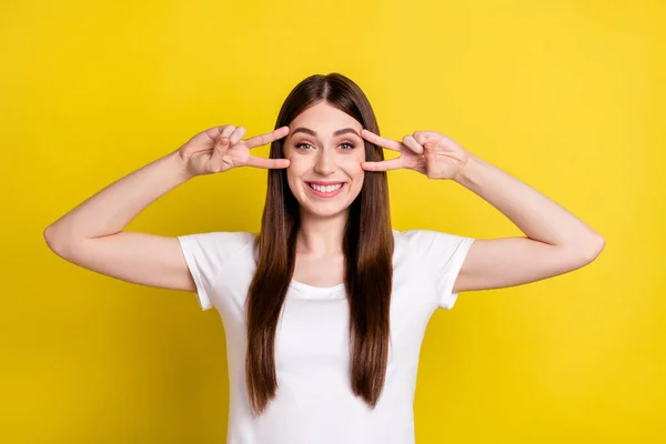 Foto av ung glad flicka glad positiv leende visa fred cool v-tecken har kul isolerad över gul färg bakgrund — Stockfoto