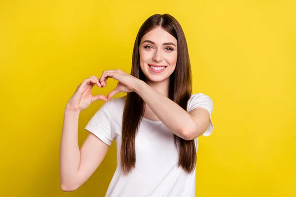 若い陽気な女の子の写真幸せな正の笑顔ショー指ハートサイン愛バレンタイン日孤立以上黄色の色の背景 — ストック写真