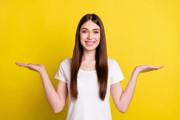 Foto de joven alegre chica feliz sonrisa positiva de las manos producto promo oferta pros contras aislado sobre fondo de color amarillo — Foto de Stock