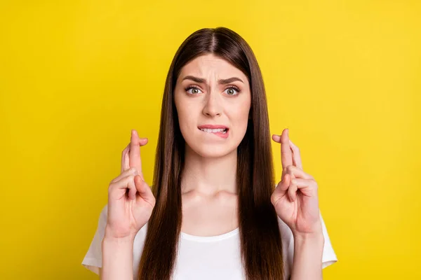 Retrato de chica preocupada atractiva sosteniendo dedos cruzados mordiendo labio problema aislado sobre fondo de color amarillo brillante —  Fotos de Stock