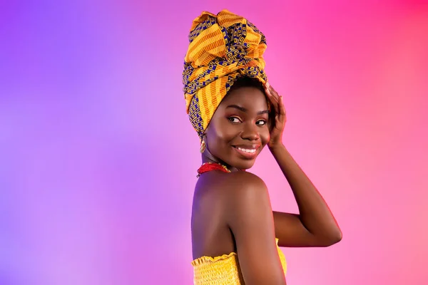 Foto de encantador agradável afro americano senhora sorriso olhar vazio espaço desgaste turbante isolado no abstrato luz fundo — Fotografia de Stock