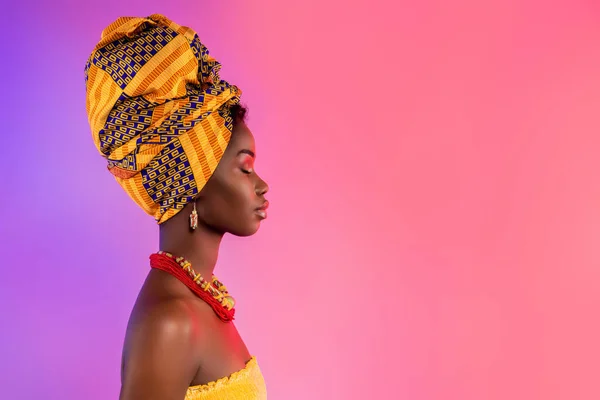 Profil sida foto av fantastiska afro amerikanska dam ser tomt utrymme bära traditionella outfit isolerad på glöd bakgrund — Stockfoto