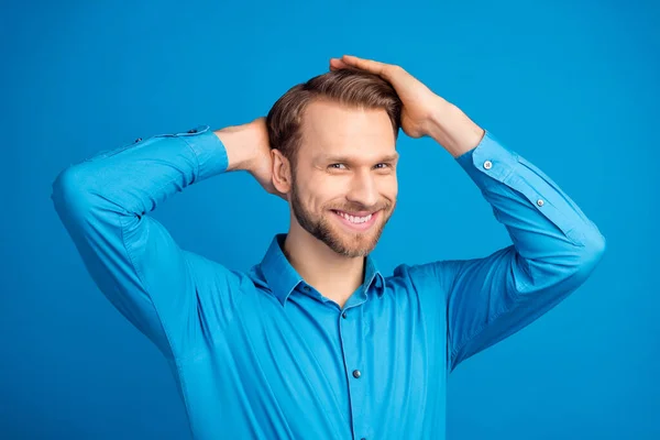 Foto de joven guapo hombre feliz sonrisa positiva manos tacto cabeza peluquería bálsamo aislado sobre fondo de color azul — Foto de Stock