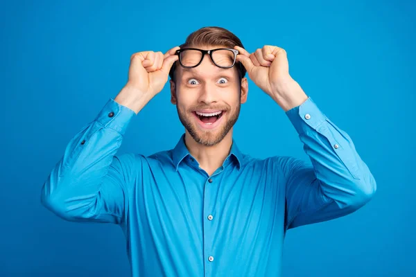 Foto do jovem surpreendido chocado surpreendido mãos toque óculos vista animado isolado sobre azul cor fundo — Fotografia de Stock