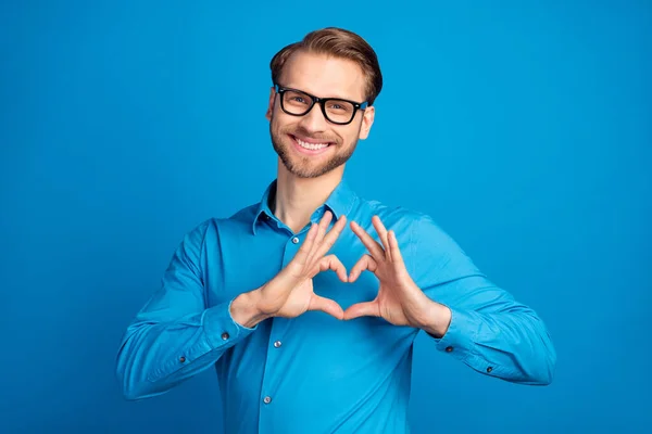 Foto di giovane felice sorriso positivo mostrare le dita simbolo del cuore amore romantico isolato su sfondo di colore blu — Foto Stock