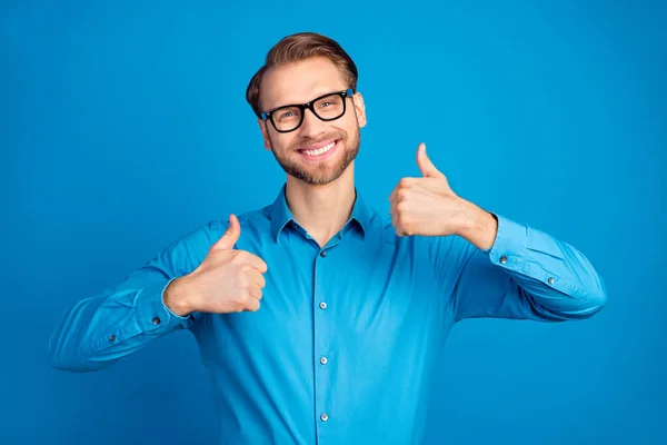 긍정적 인 미소를 짓고 있는 젊은 남성의 사진은 파란 배경 위에 고립된 멋진 피드백 조언 과같은 엄지를 보여 줍니다. — 스톡 사진