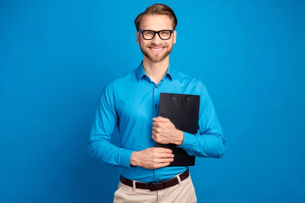 Foto de joven hombre de negocios feliz sonrisa positiva mantenga portapapeles organizador aislado sobre fondo de color azul — Foto de Stock