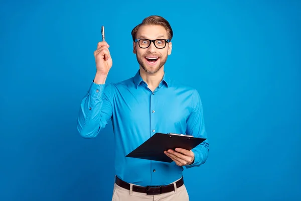 Fénykép a fiatal férfi boldog pozitív mosoly van egy ötlet megoldás döntés toll szervező elszigetelt kék színű háttér — Stock Fotó