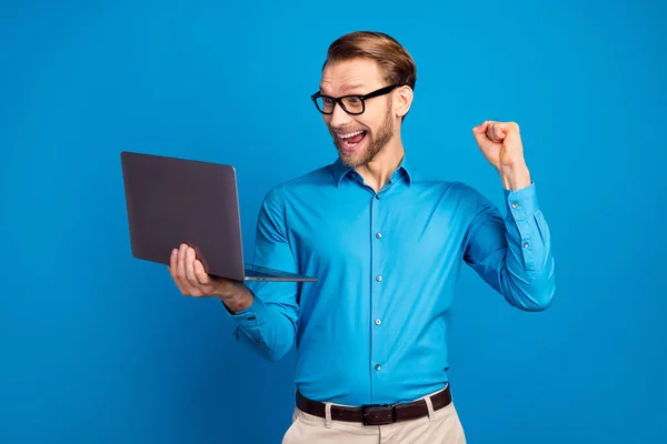 Foto van jonge zakenman blij positieve glimlach kijk laptop vieren overwinning geluk succes geïsoleerd over blauwe kleur achtergrond — Stockfoto