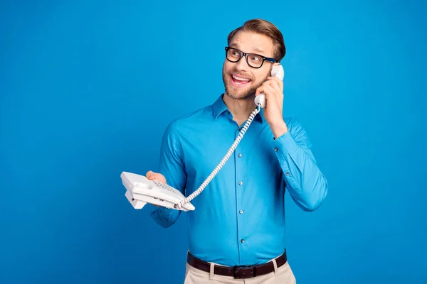 Foto van de jongeman blij positieve glimlach oproep praten gesprek telefoon kijken lege ruimte geïsoleerd over blauwe kleur achtergrond — Stockfoto