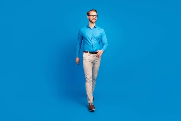 Pełna długość zdjęcie młody biznes człowiek szczęśliwy pozytywny uśmiech pewny go spacer wygląd puste miejsce izolowane nad niebieskim tle koloru — Zdjęcie stockowe