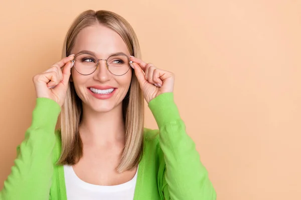 Porträtt av attraktiva glada intelligent flicka vidröra specifikationer tittar åt sidan kopiera utrymme annons isolerad över beige pastell färg bakgrund — Stockfoto