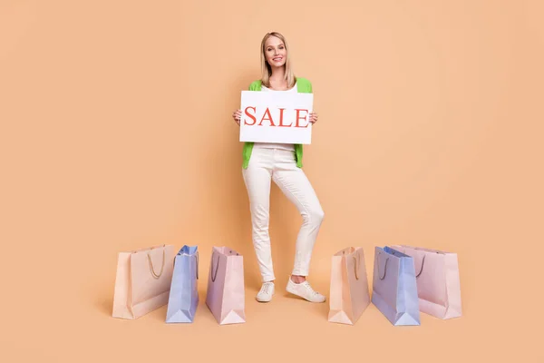 Volledige lengte body size foto vrouw in de buurt van tassen na het winkelen houden verkoop tafel geïsoleerde pastel beige kleur achtergrond copyspace — Stockfoto