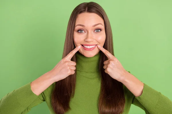 Foto ritratto felice donna puntando il dito sui denti bianchi isolato pastello sfondo di colore verde — Foto Stock