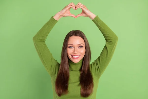 Foto retrato mulher feliz mostrando sinal de coração com dedos isolado pastel cor verde fundo — Fotografia de Stock
