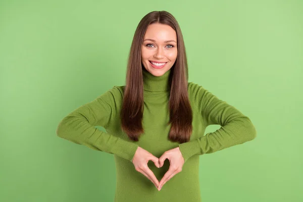 Foto portrét šťastná žena ukazující srdce s prsty s úsměvem izolované pastelové zelené pozadí — Stock fotografie
