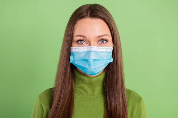 年轻严肃女子戴口罩保护流行病科罗纳的照片，在绿色背景下隔离 — 图库照片
