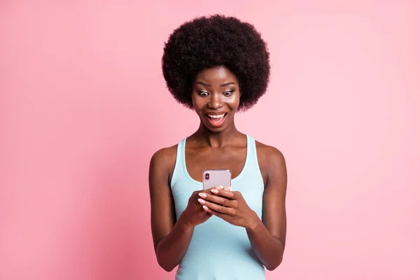 Foto van trendy gelukkig mooie donkere huid dame houden kijken telefoon als reactie melding geïsoleerd op roze kleur achtergrond — Stockfoto