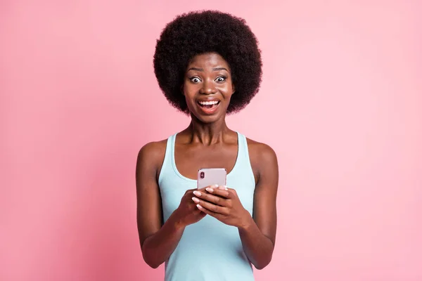 Photo of beautiful young dark skin kobieta hold phone aktualności social media izolowane na różowym tle koloru — Zdjęcie stockowe