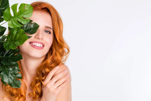 Foto retrato de menina com cabelos vermelhos encaracolados com pele macia natural perto de folhas verdes planta tocando ombros isolado cor branca fundo copyspace — Fotografia de Stock