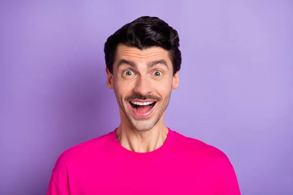 Foto van funky onder de indruk jonge man gekleed roze t-shirt grote ogen open mond geïsoleerde violette kleur achtergrond — Stockfoto