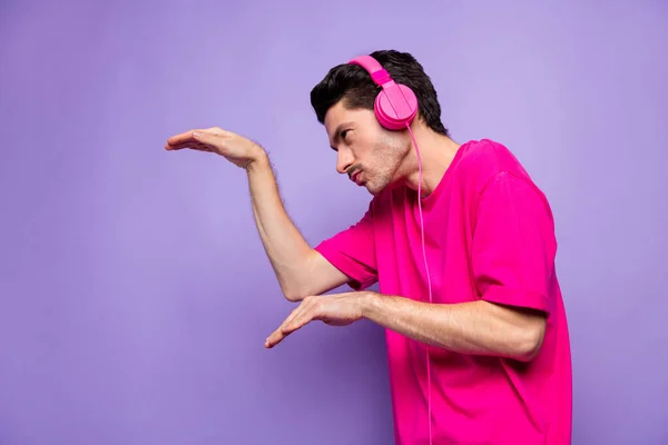 Profil côté photo de jeune funky drôle homme négligent dans les écouteurs regarder copyspace danse isolé sur fond de couleur pourpre — Photo